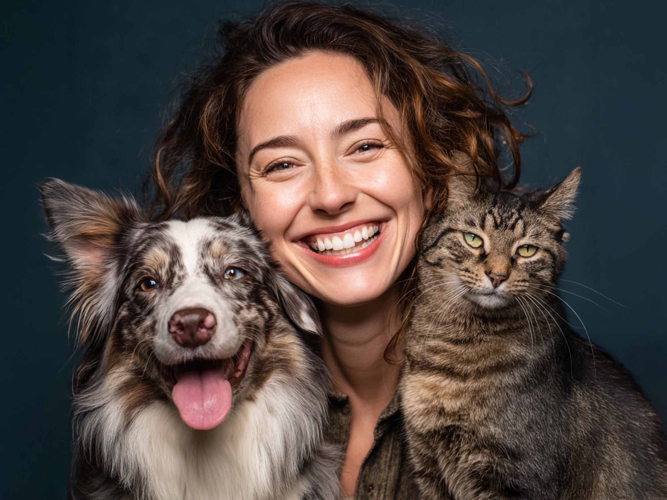 Uma mulher posando com um cachorro e um gato